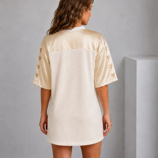 Woman wearing a cream-colored satin nightshirt against a plain background